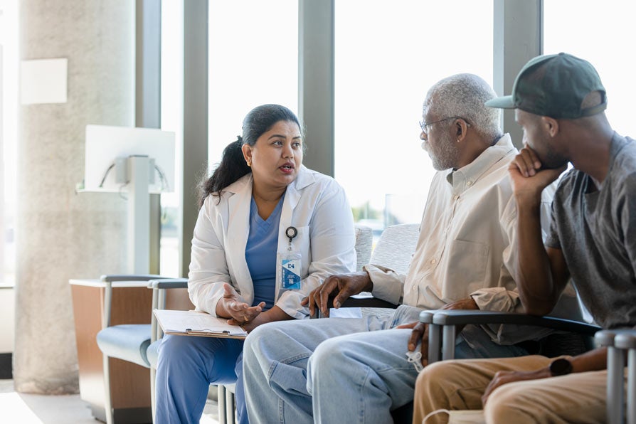 A doctor talks to an older man and his son
