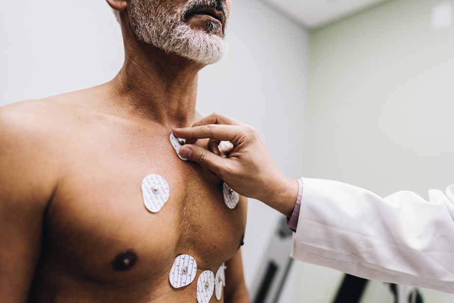 Close-up of human hands putting sensors of electrocardiography